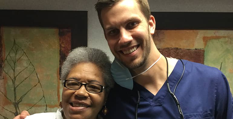 A dentist hugging a smiling patient