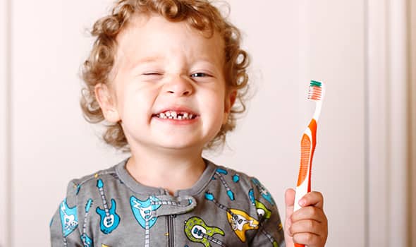 Smiling kid holding a toothbrush